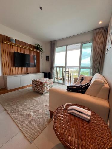 a living room with a couch and a flat screen tv at Mandai Apartamentos in Cabo Frio