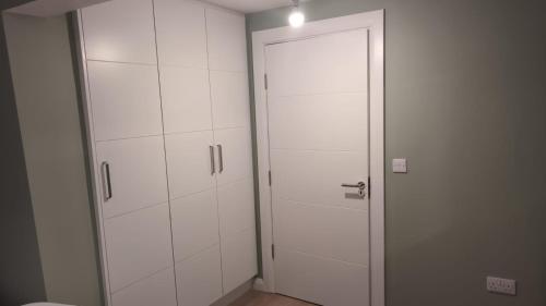 a white closet with a door in a room at Eyre Square View in Galway