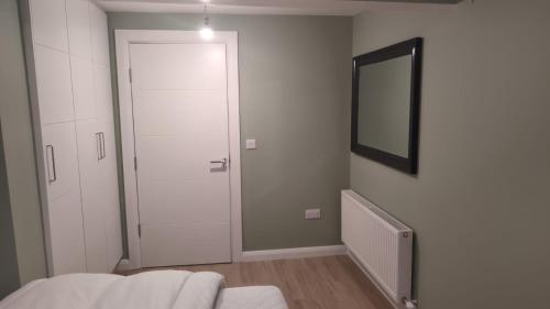 a white room with a door and a mirror at Eyre Square View in Galway