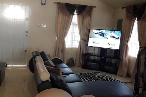 a living room with a couch and a flat screen tv at 2 Bed-2 bath-AirCon-Parking-New Harbour Village 3 in Mendes