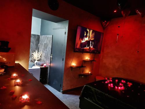 a red room with a table and a tv on the wall at Love Room Jacuzzi in Lyon