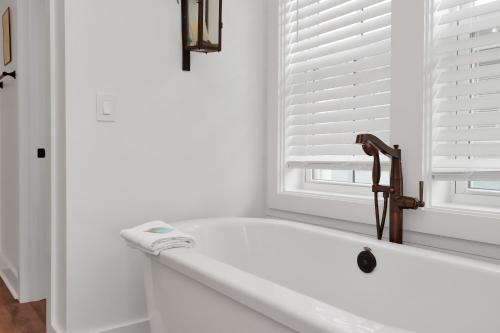 a white bathroom with a bath tub and a window at Turtle Time by Pristine Properties Vacation Rentals in Indian Pass