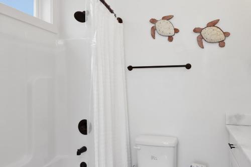 a bathroom with a white shower curtain and a toilet at Turtle Time by Pristine Properties Vacation Rentals in Indian Pass