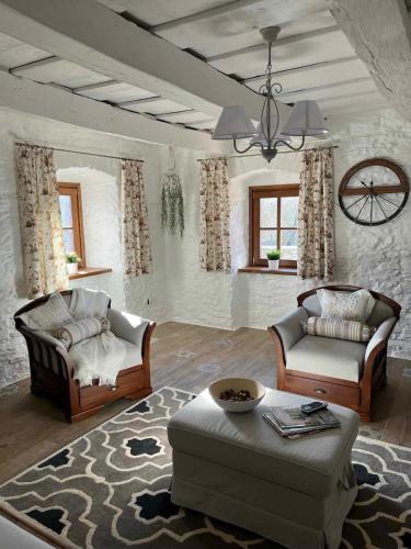a living room with two chairs and a couch at Thatched cottage in Dörgicse