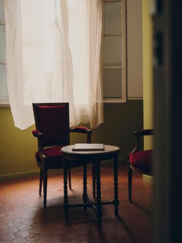 a room with two chairs and a table and a window at La Maison d'Odette in La Ciotat