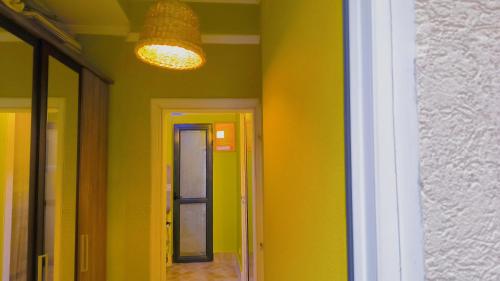 a hallway with yellow walls and a light fixture at Apartament - Lisa in Budva