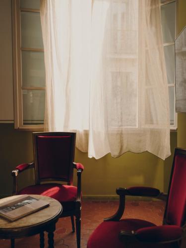 a room with two chairs and a table and a window at La Maison d'Odette in La Ciotat
