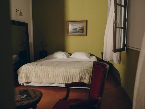 a bedroom with a bed and a picture on the wall at La Maison d'Odette in La Ciotat
