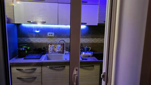 a kitchen with white cabinets and a sink at Apartament - Lisa in Budva