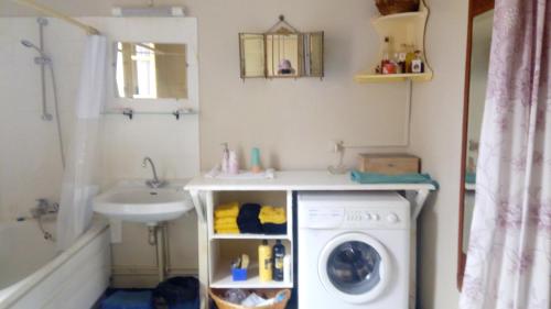 une salle de bain avec une machine à laver et un lavabo dans l'établissement Grande Maison avec Piscine, juillet et août, Jardin Privatives à NYONS, à Nyons