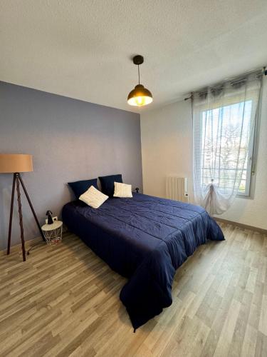 une chambre avec un lit bleu et une fenêtre dans l'établissement Le Toulousain T3 Parking Calme, à Toulouse