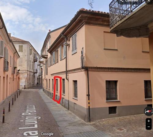 an alley with buildings and red doors on a street at Casa Bùgia Nen in Alba