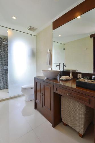 a bathroom with a sink and a toilet and a mirror at The Khayangan Dreams Villa, Seminyak in Seminyak