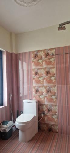 a bathroom with a toilet and a wall at Myra 3 bedrooms whole house in Kathmandu