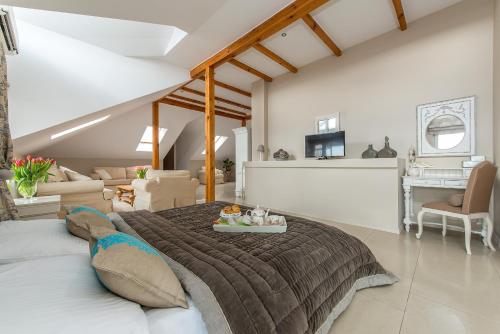 a bedroom with a large bed and a living room at Riviera Resort Airport Modlin in Olszewnica Nowa