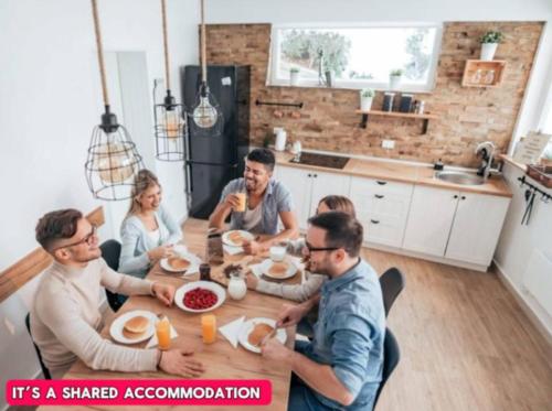 a group of people sitting around a table eating food at -RA27A- For your relaxed, Cosy stay, Free Parking in Leeds