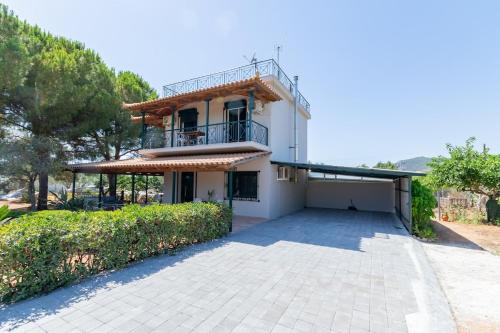 a white house with a balcony and a driveway at Pinest in Rikia