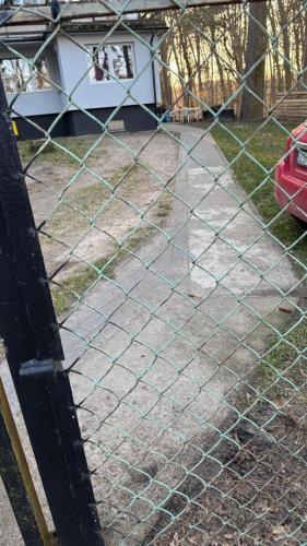 a chain link fence in front of a yard at Lake House Hostel in Szczecin