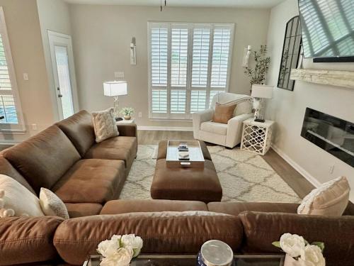 a living room with a brown couch and a table at Aggieland Retreat in Bryan