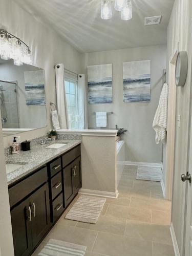 a bathroom with two sinks and a tub and a shower at Aggieland Retreat in Bryan