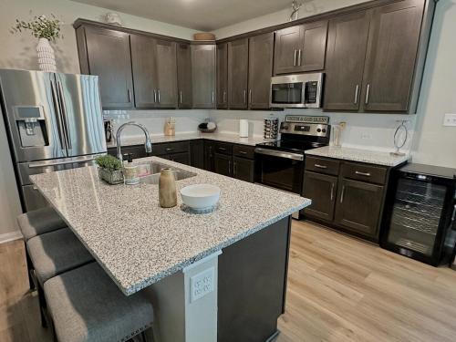 a kitchen with wooden cabinets and a granite counter top at Aggieland Retreat in Bryan