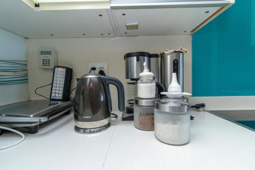 a kitchen counter with various appliances on a counter top at Modern Seaview Apartment in Summerstrand
