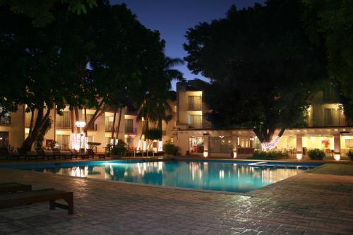 uma piscina em frente a um edifício à noite em Hotel Viva Villahermosa em Villahermosa