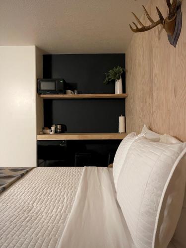 a bedroom with a white bed and a desk at Outdoors Inn in Sandpoint