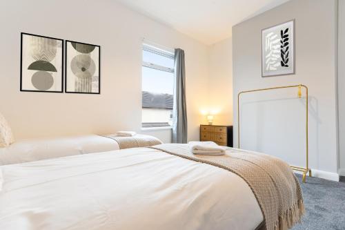 Un dormitorio con dos camas y una gran ventana. en Herschell House - Central Location - Free Parking, Fast Wifi, SmartTV with Netflix by Yoko Property, en Redcar
