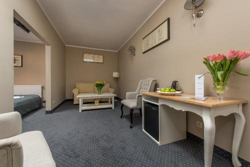 a hotel room with a desk with flowers on it at Riviera Resort Airport Modlin in Olszewnica Nowa