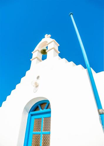 a church with a blue window and a street light at Ornos Blue in Ornos