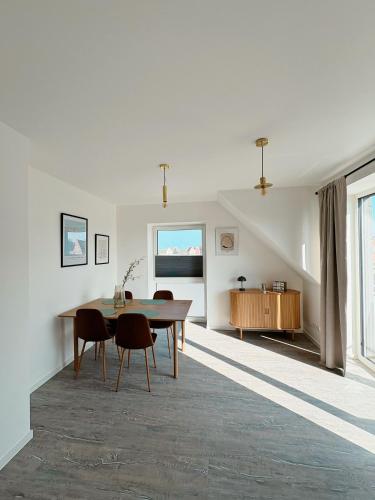 a dining room with a table and chairs at Ferienwohnung KÖÖK Heimathafen - Modern, Balkon, Strandnah in Neuharlingersiel