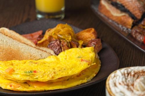 a plate of breakfast food with eggs and toast at Four Points by Sheraton Caguas Real in Caguas