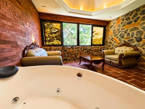 a bath tub in a room with a brick wall at Le Suisse Spa in Santa Lucía Milpas Altas