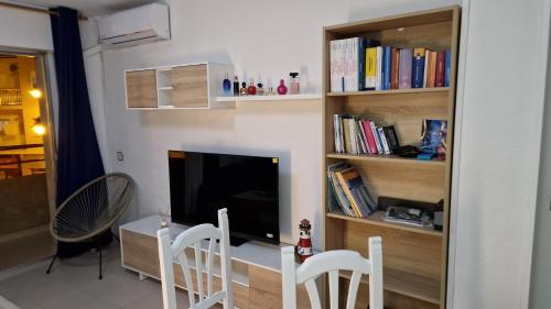 a living room with a tv and a table and chairs at Casa del Mar in Puerto de Mazarrón