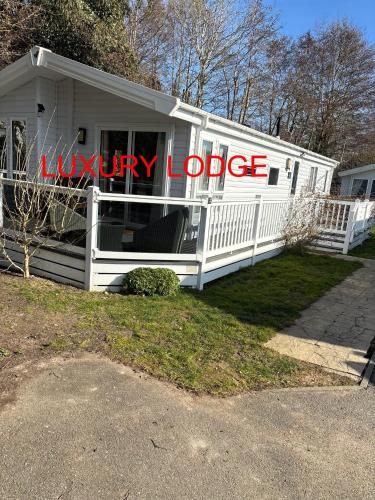 a white house with a luxury lodge sign on it at Luxury lodge T11 in Hastings