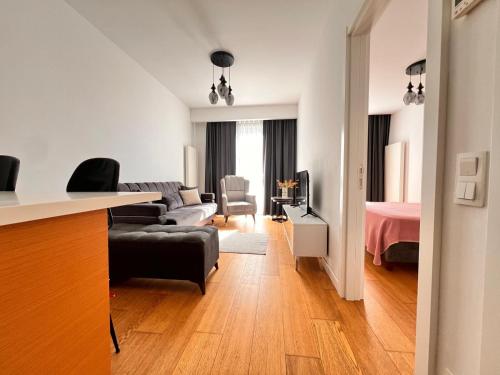 a living room with a couch and a bedroom at G Tower Residence at Divan Near To Mimar Sinan Metro Station in Istanbul