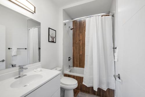 a white bathroom with a toilet and a sink at Urban Retreat Studio - Balcony Smart Design in Philadelphia