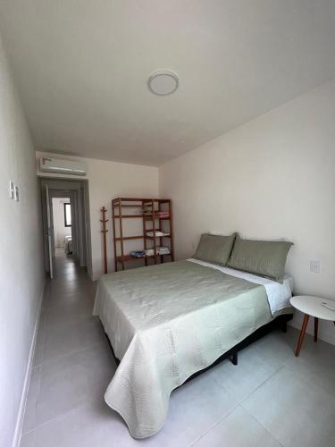 a bedroom with a large bed and a table at Itacimirim Beach Unique in Camacari