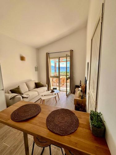 un salon avec une table et un canapé dans l'établissement Appartement face à la mer avec vue imprenable !, à Lumio