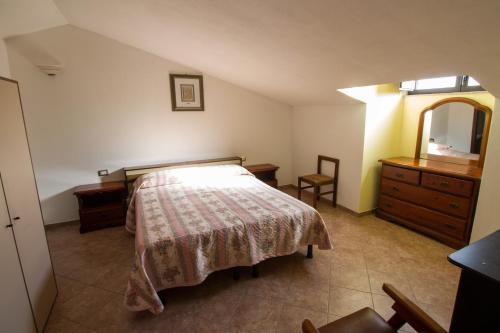 a bedroom with a bed and a dresser and a mirror at Attico Bella Vista in Siniscola