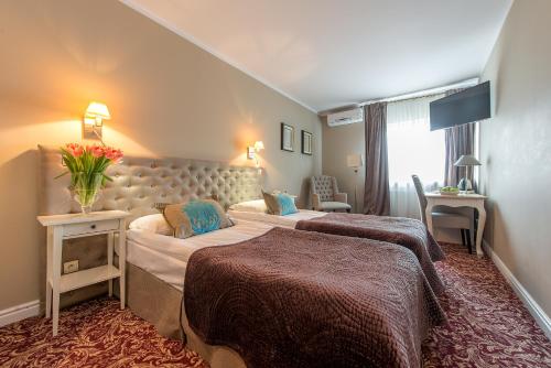 a hotel room with two beds in a room at Riviera Resort Airport Modlin in Olszewnica Nowa