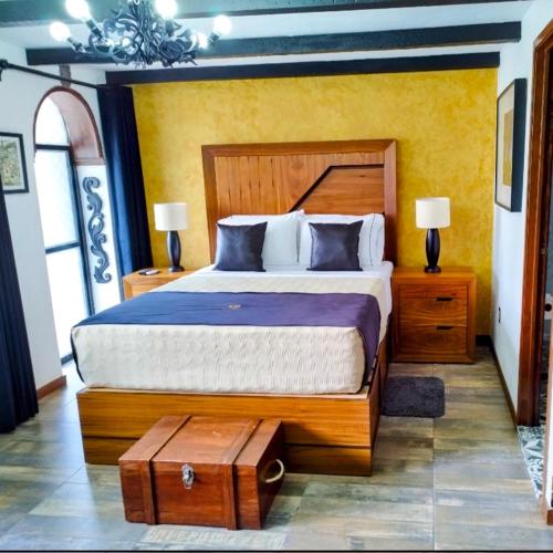 a bedroom with a large bed with a wooden headboard at Hotel Boutique La Mansión Guadalajara in Guadalajara