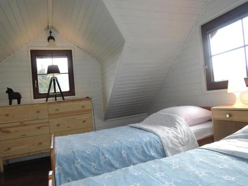 a bedroom with a bed and a dresser and a window at Wooden House by Baltic Sea & Wolin Park in Międzyzdroje