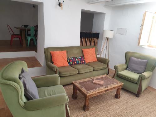 a living room with two chairs and a couch and a table at Casa del Ciervo - Más que apartamentos in Cortijo Prados