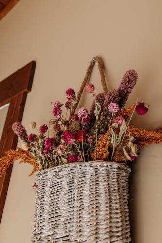 a wicker basket filled with flowers on a wall at Sojourner's Lodge & Log Cabin Suites in Dundee