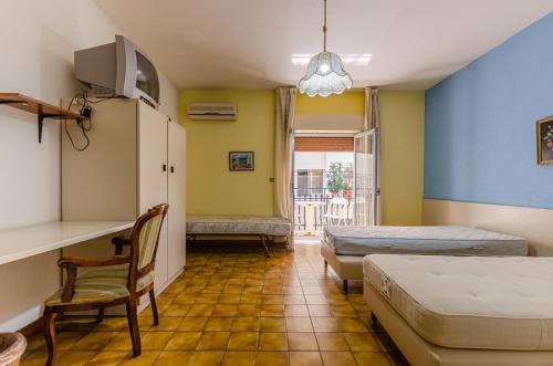 a room with two beds and a chair in it at Le Tartarughe Aparthotel in Letojanni