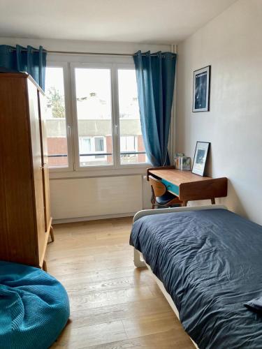 une chambre avec un lit, un bureau et une fenêtre dans l'établissement Cosy apartment with a magnificent view 10 min from Paris Exhibition Centre, à Issy-les-Moulineaux