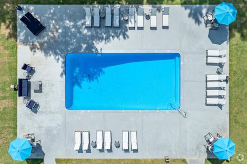 an overhead view of a swimming pool with blue umbrellas at Park At London F4 I Spacious 2 Bed 2 Bath in Ellenwood