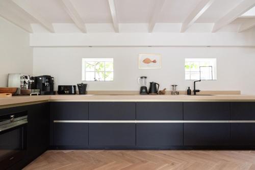 a kitchen with black and white counter tops at De Vijf Suites in Elp